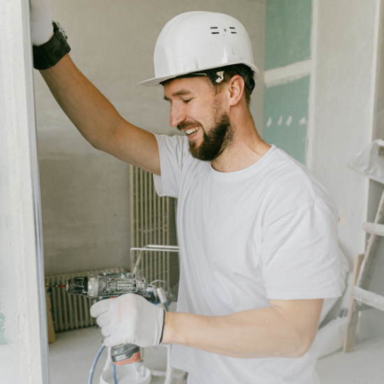 Man painting wall in hard hat.